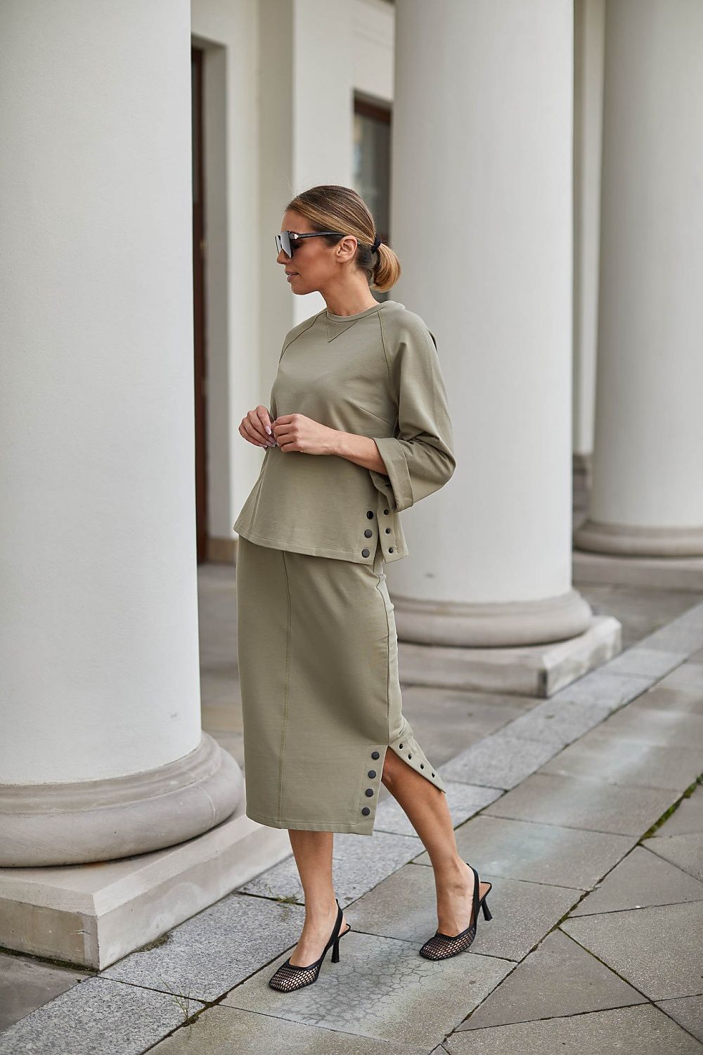 Jupe midi verte fendue sur le côté avec boutons décoratifs, idéale pour une tenue chic et élégante.