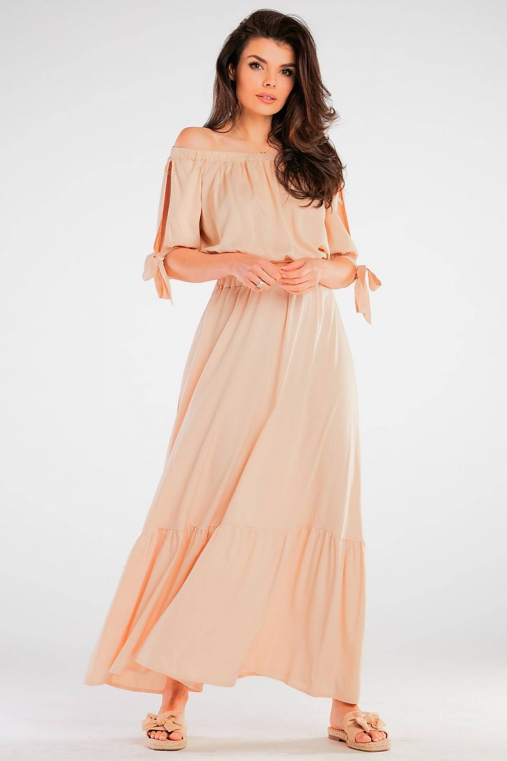 Jupe longue fluide beige pour femme avec coupe évasée et détails de noeuds aux manches, parfaite pour un look élégant.