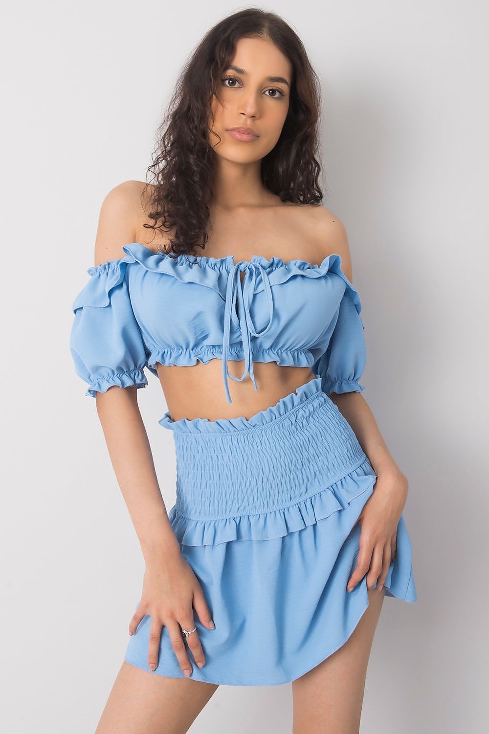 Jupe courte bleue plissée avec ourlet à volant pour un look frais et estival, idéale pour une tenue décontractée ou habillée.