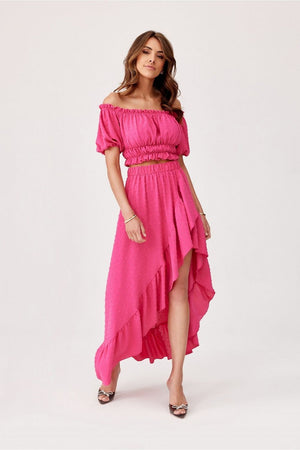 Jupe longue rose asymétrique avec taille élastiquée, parfaite pour une tenue estivale élégante et confortable.