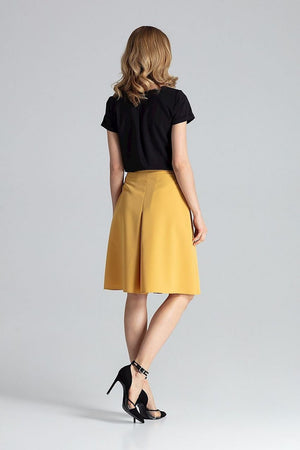 Jupe midi trapèze jaune élégante, idéale pour une tenue chic, combinée avec haut noir et talons aiguilles.